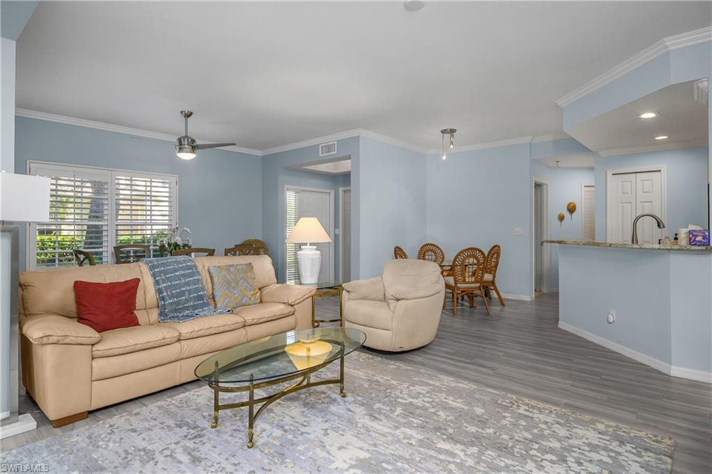 963 Egrets Run, Unit 102 Naples, FL 34108 - Photo 13 of 39 a living room with furniture and a large window