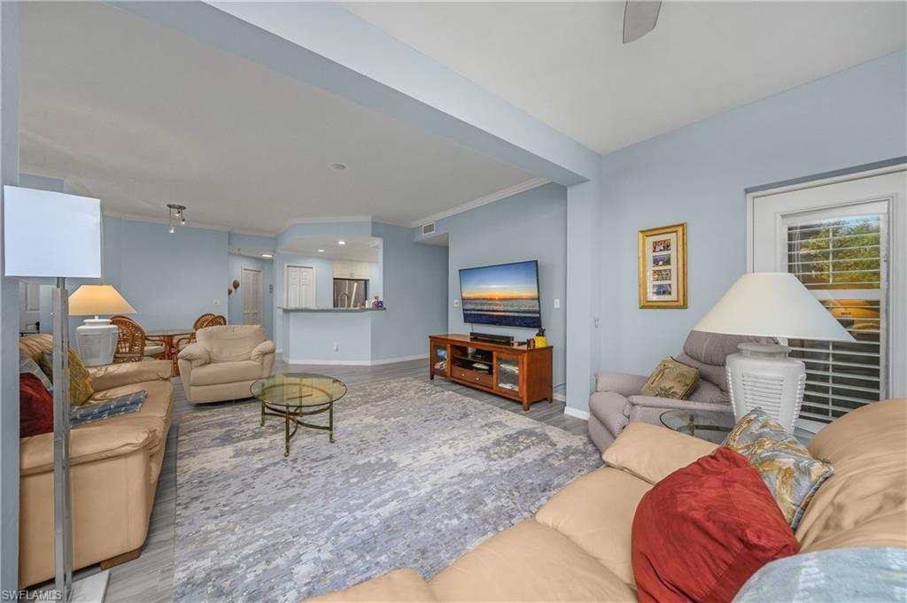 963 Egrets Run, Unit 102 Naples, FL 34108 - Photo 15 of 39 a living room with furniture and a flat screen tv