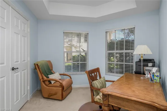 a view of a workspace with furniture and a window