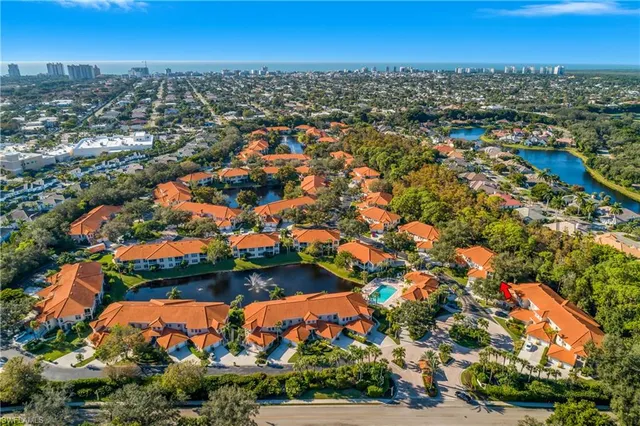 an aerial view of residential houses with outdoor space and trees