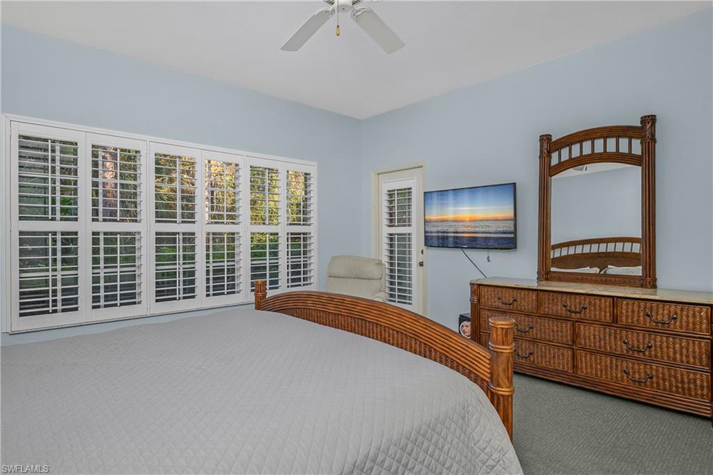 963 Egrets Run, Unit 102 Naples, FL 34108 - Photo 21 of 39 a bedroom with a bed and a dresser next to a window