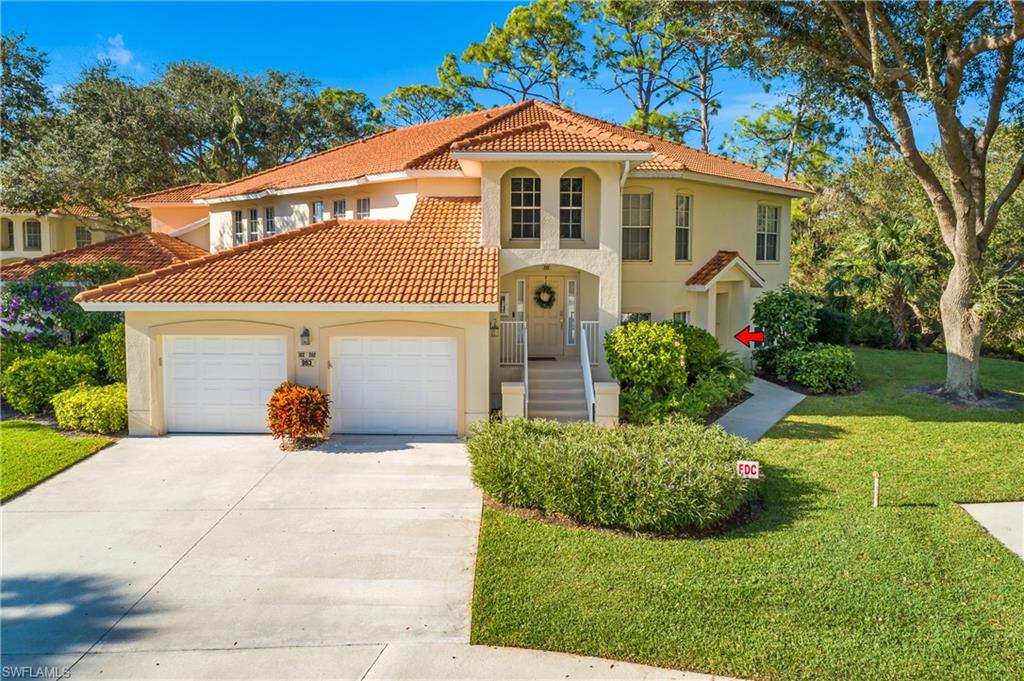 963 Egrets Run, Unit 102 Naples, FL 34108 - Photo 27 of 39 a front view of a house with a yard and garage