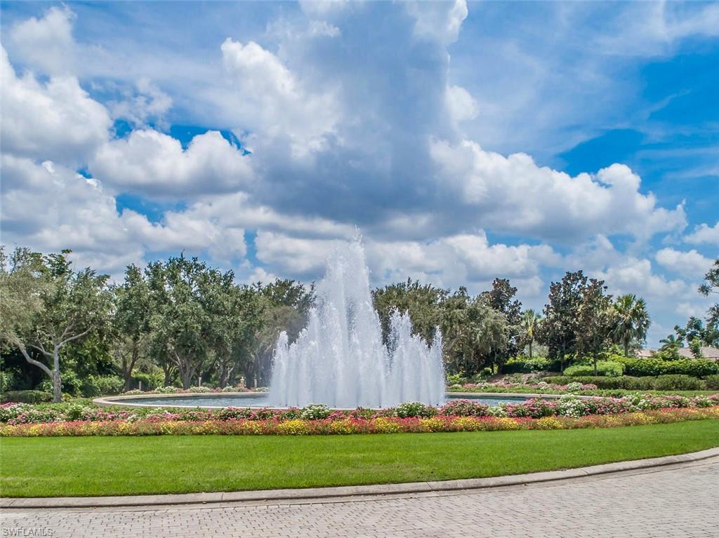 963 Egrets Run, Unit 102 Naples, FL 34108 - Photo 28 of 39 a front view of a multi story residential apartment building with yard and green space