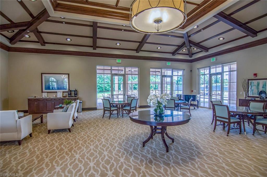 963 Egrets Run, Unit 102 Naples, FL 34108 - Photo 32 of 39 a living room with furniture a rug potted plant and a chandelier