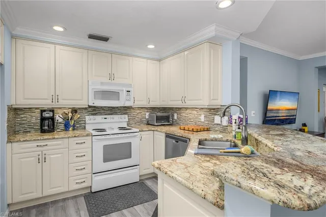 a kitchen with white cabinets and appliances