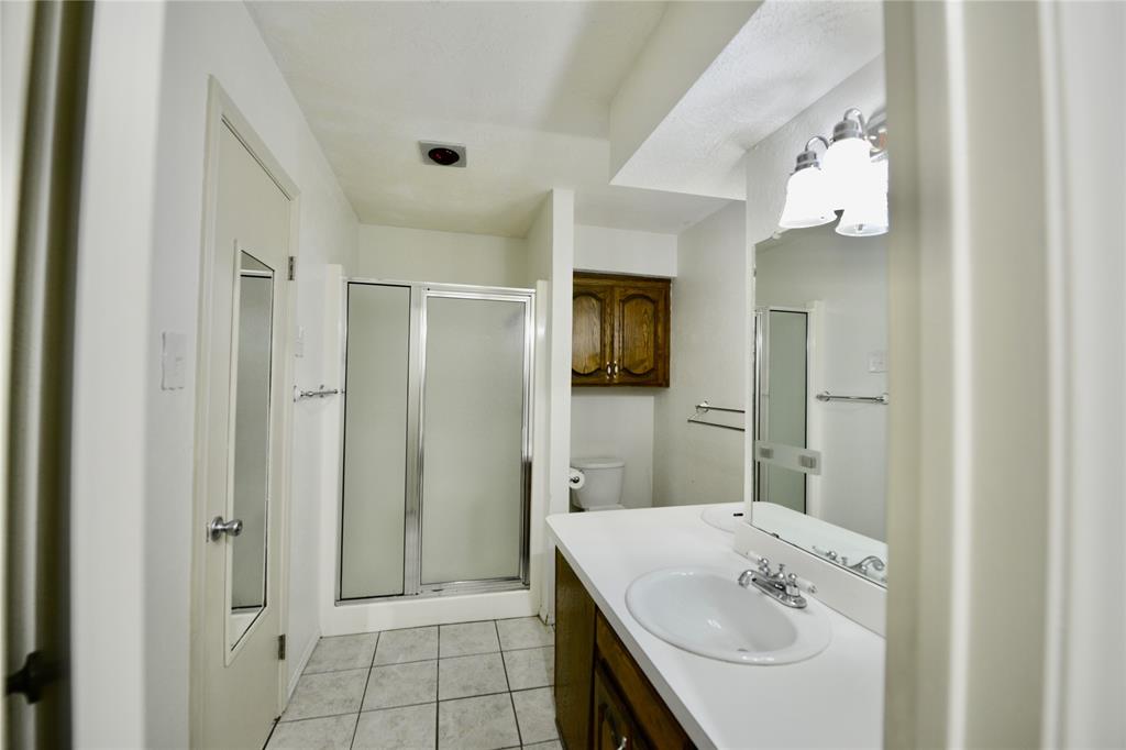 2021 Mill Pond Road Garland, TX 75044 - Photo 11 of 20 a bathroom with a sink a toilet and shower