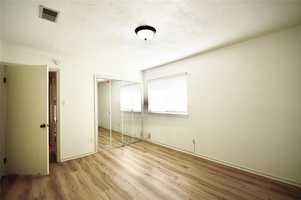 2021 Mill Pond Road Garland, TX 75044 - Photo 16 of 20 a view of an empty room with wooden floor and a window