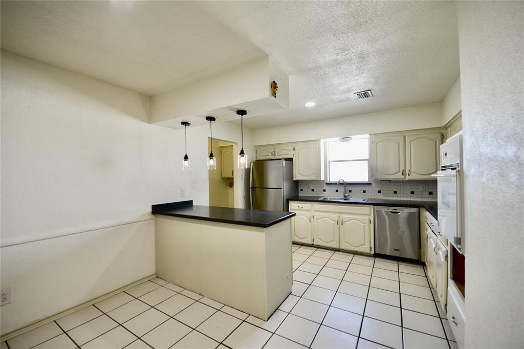 2021 Mill Pond Road Garland, TX 75044 - Photo 5 of 20 a kitchen with stainless steel appliances granite countertop a refrigerator and a stove