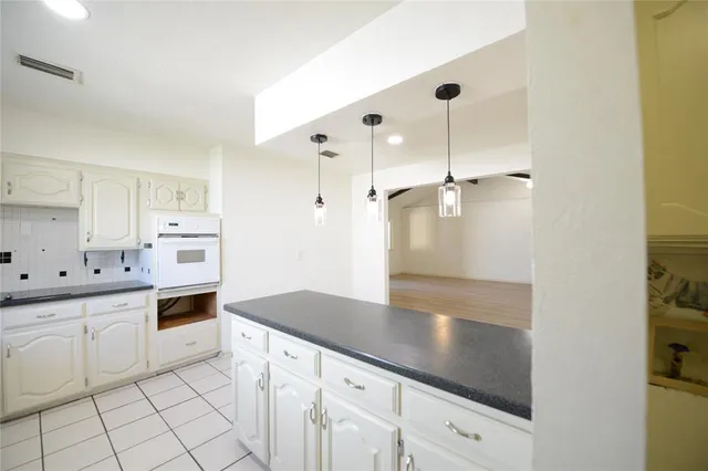 a kitchen with granite countertop white cabinets and white appliances