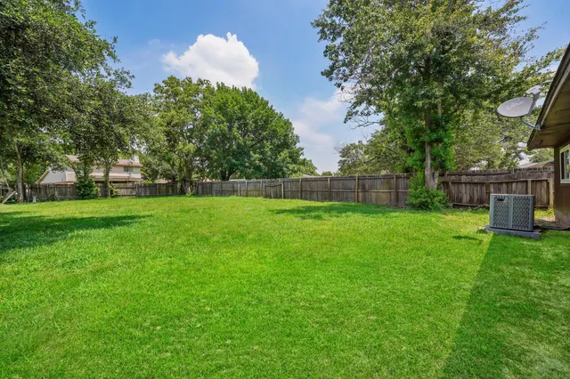a view of yard with green space and trees