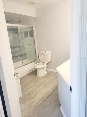 a view of a hallway with wooden floor and entryway