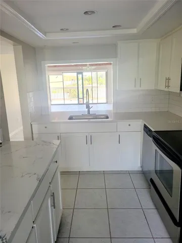 a kitchen with a sink a stove and cabinets