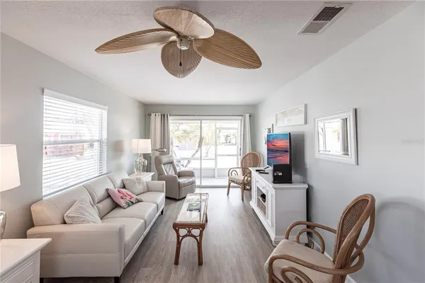 a living room with furniture ceiling fan and a window