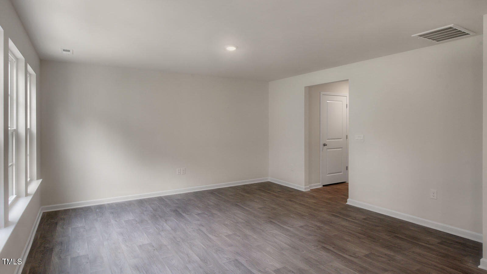 613 Stream Walk Crossing Wendell, NC 27591 - Photo 10 of 32 an empty room with wooden floor and windows