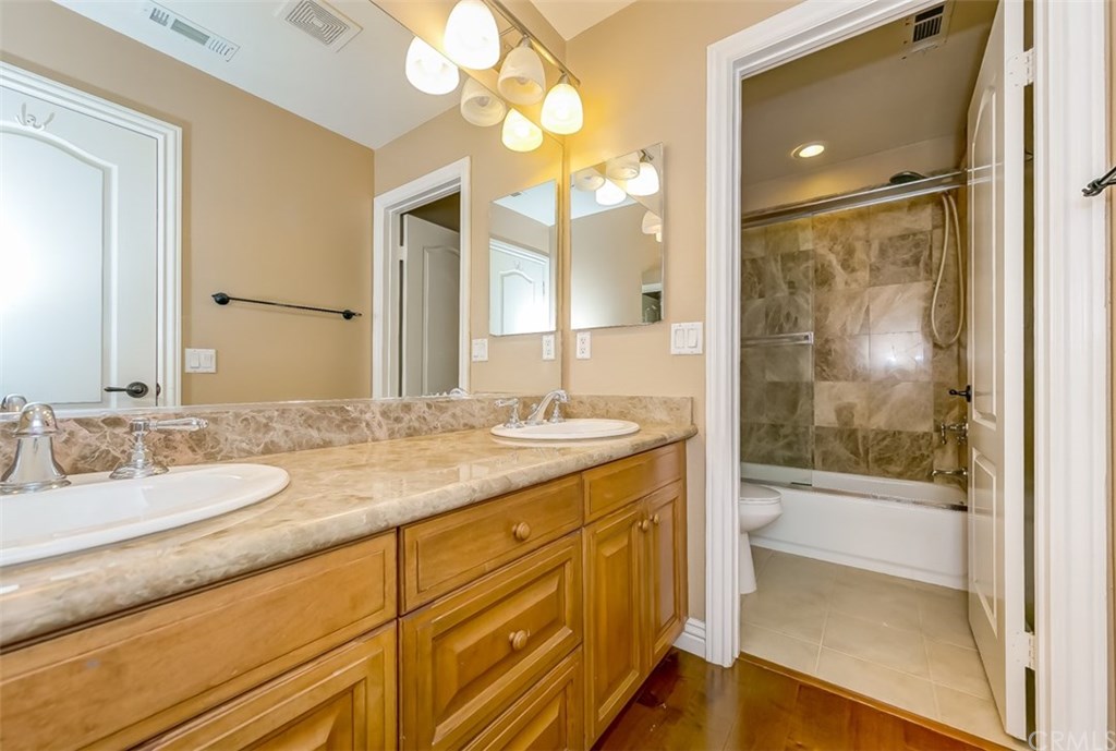 31 Climbing Vine Irvine, CA 92603 - Photo 12 of 20 a bathroom with a granite countertop sink mirror and shower