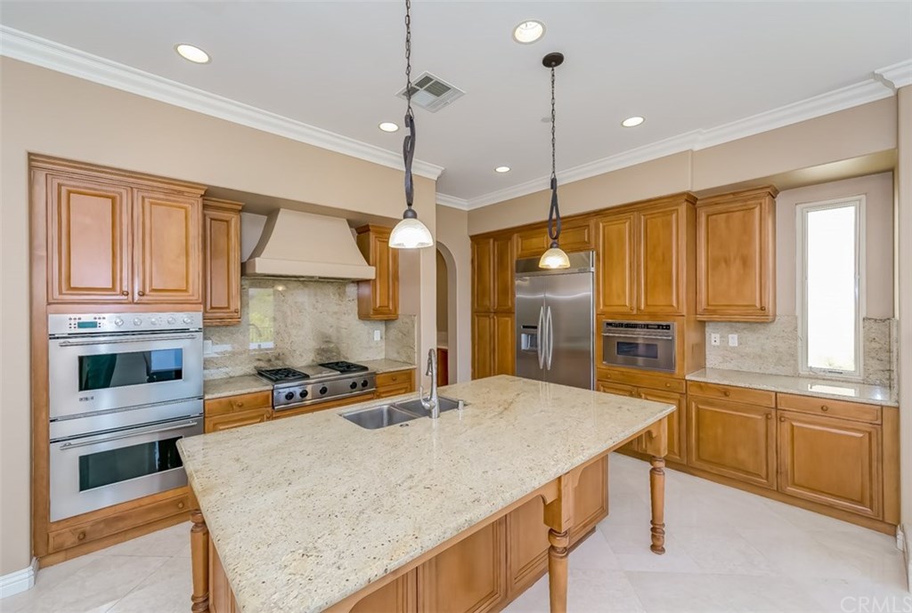 31 Climbing Vine Irvine, CA 92603 - Photo 8 of 20 a kitchen with stainless steel appliances kitchen island granite countertop a sink and counter space