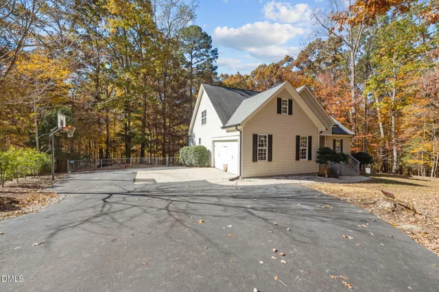 a view of a house with a yard and large trees