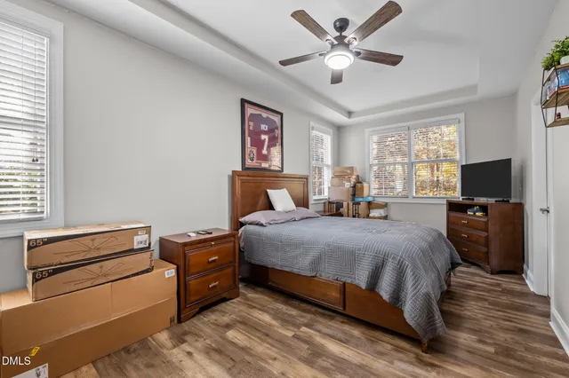 a bedroom with bed tv and a window