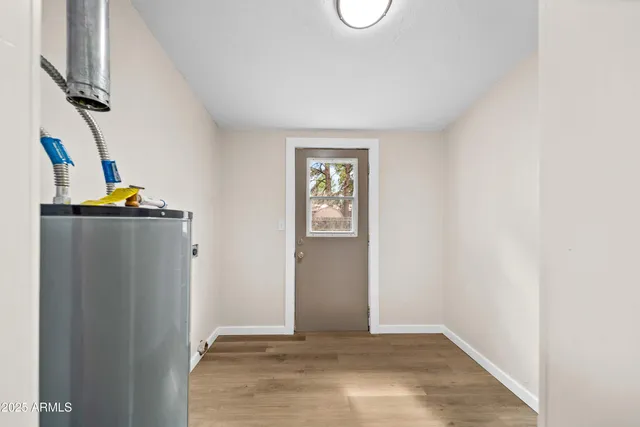 a view of empty room with wooden floor and window