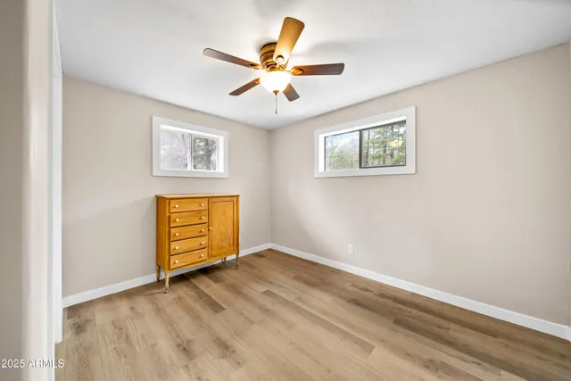 an empty room with window and ceiling fan
