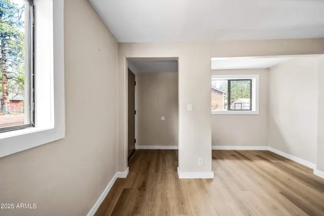 a view of a room with wooden floor and a window