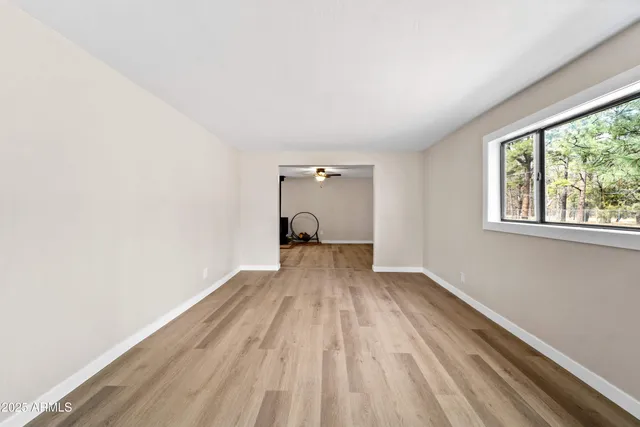 a view of a room with wooden floor and a window