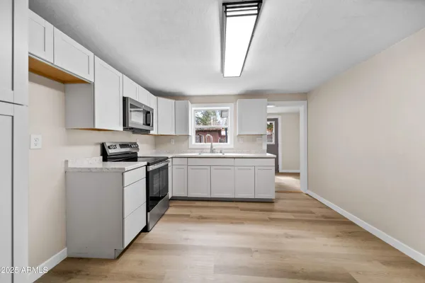 a kitchen with sink a microwave and cabinets