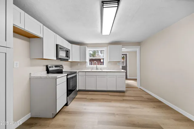 a kitchen with sink a microwave and cabinets