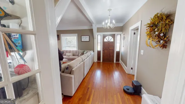 a view of a hallway and a livingroom with furniture