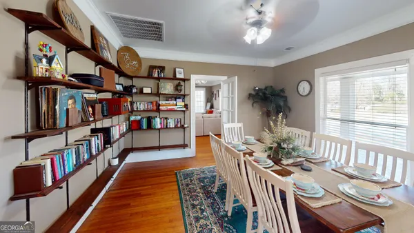 a view of a hallway with wooden floor and a living room