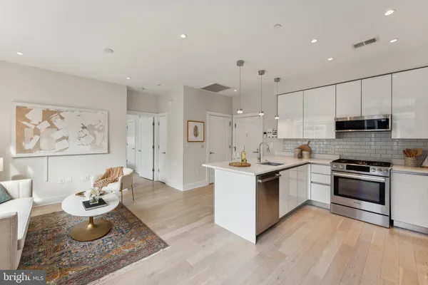 a kitchen with stainless steel appliances kitchen island granite countertop a stove a sink and a refrigerator