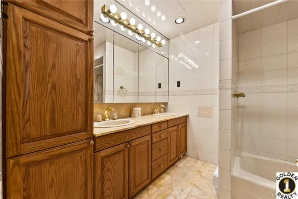 a bathroom with a double vanity sink a mirror and a shower