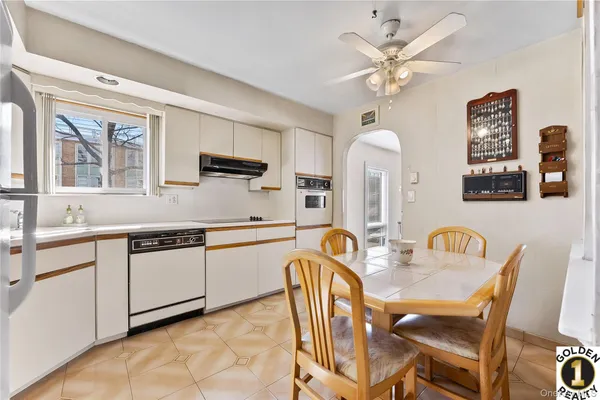 a kitchen with a dining table chairs stainless steel appliances and cabinets