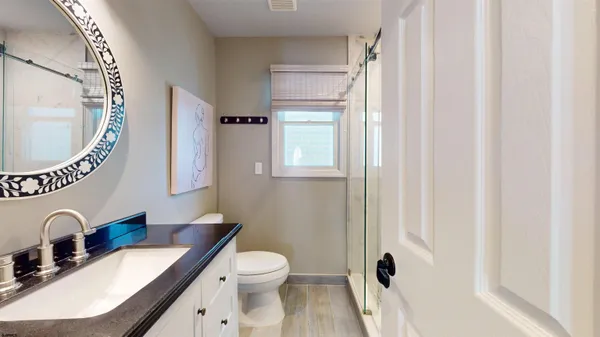 a bathroom with a granite countertop sink mirror vanity and toilet