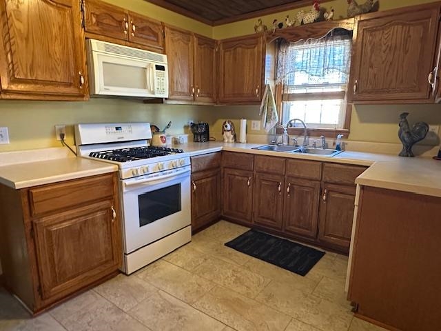 1555 Rich Road Savannah, TN 38372 - Photo 4 of 18 Kitchen with light countertops, a sink, brown cabinets, and white appliances