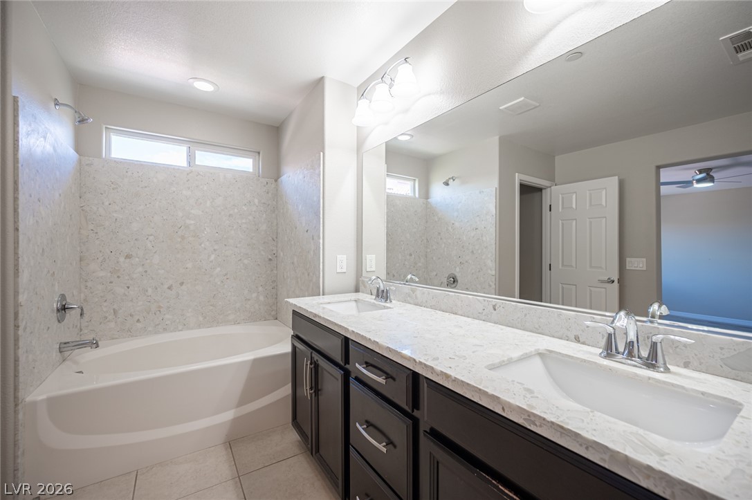 9916 Sable Point Street Las Vegas, NV 89178 - Photo 47 of 73 A pristine primary bath showcases a generous soaking tub and sleek double vanity, offering a serene retreat.