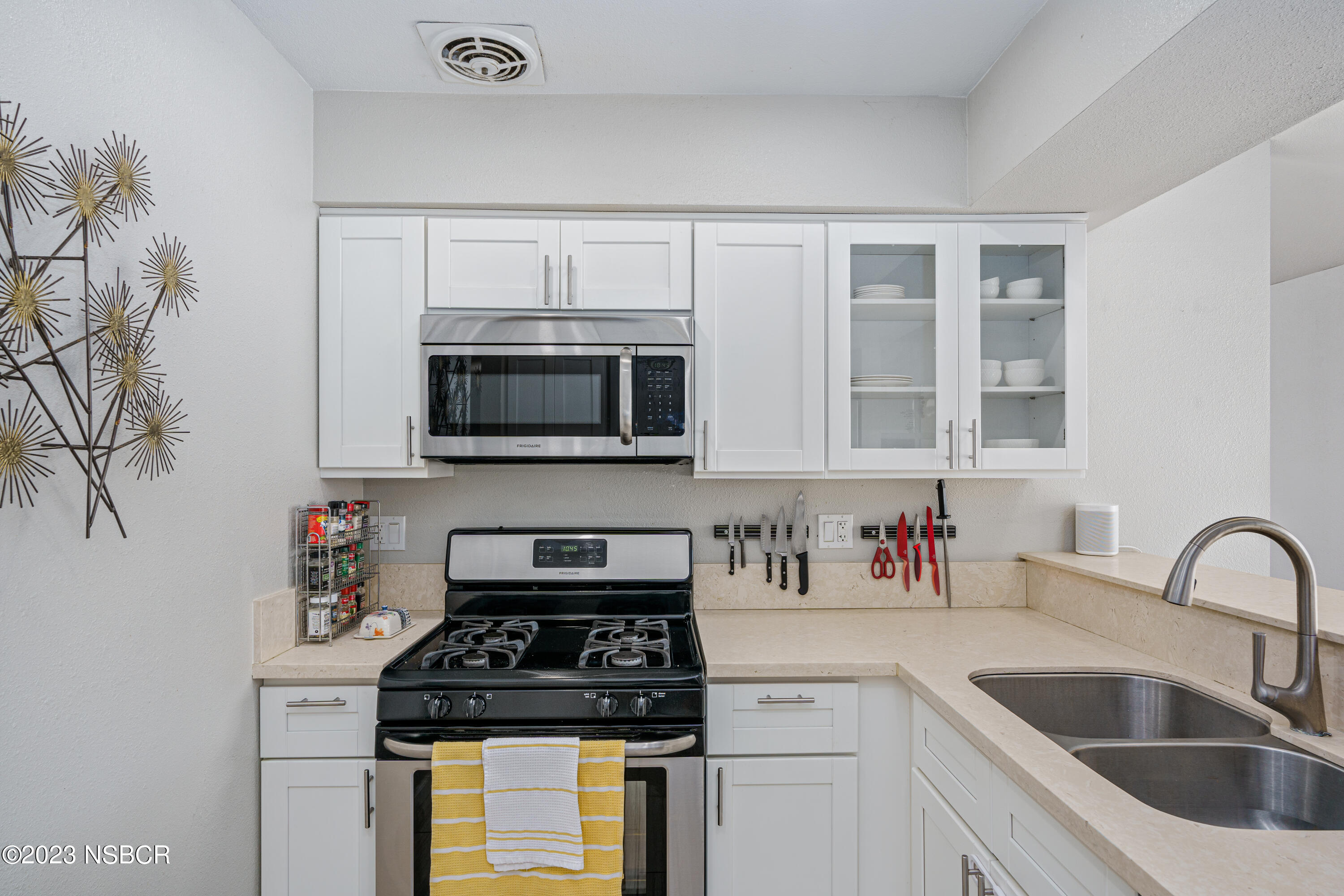 509 North Poppy Street Lompoc, CA 93436 - Photo 12 of 36 a kitchen with white cabinets a sink stove and microwave