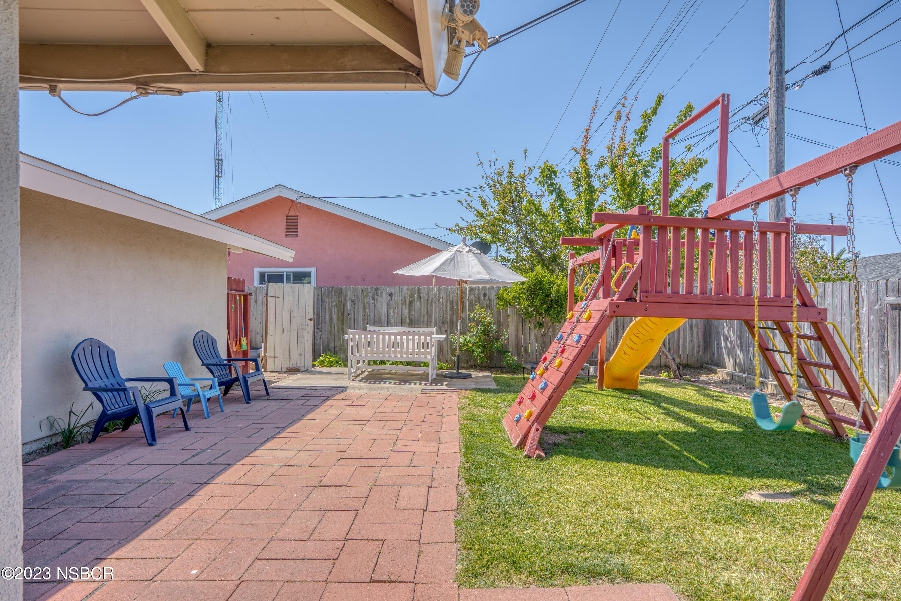 509 North Poppy Street Lompoc, CA 93436 - Photo 26 of 36 a view of a backyard with a slide and a table and chairs