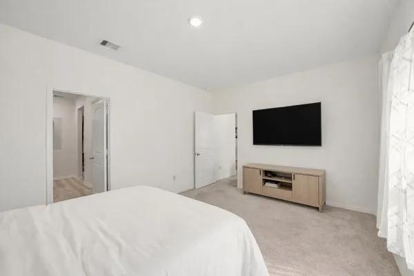 a bedroom with a bed and a flat screen tv