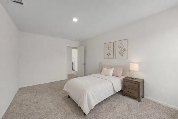 a bedroom with a bed and a night stand