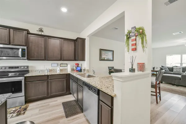 a kitchen with stainless steel appliances granite countertop a sink stove and refrigerator