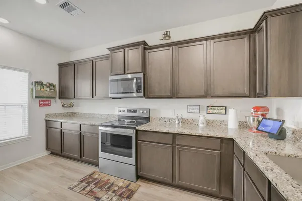 a kitchen with stainless steel appliances granite countertop a sink stove and refrigerator
