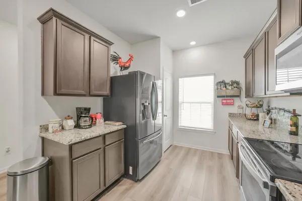 a kitchen with refrigerator cabinets and wooden floor