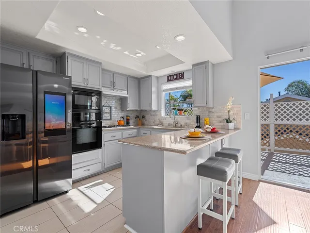 a kitchen with stainless steel appliances kitchen island granite countertop a refrigerator and a stove top oven