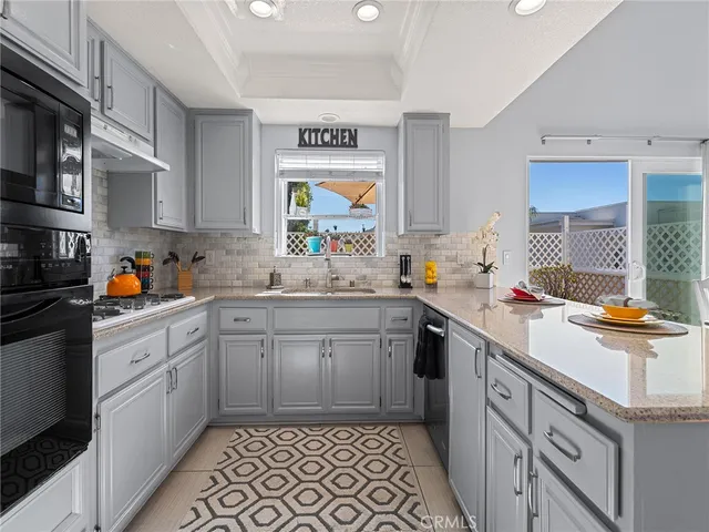 a living room with furniture kitchen view and a window