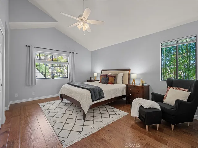 a bedroom with a bed wooden floor and window
