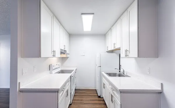 a kitchen with a sink a stove and cabinets