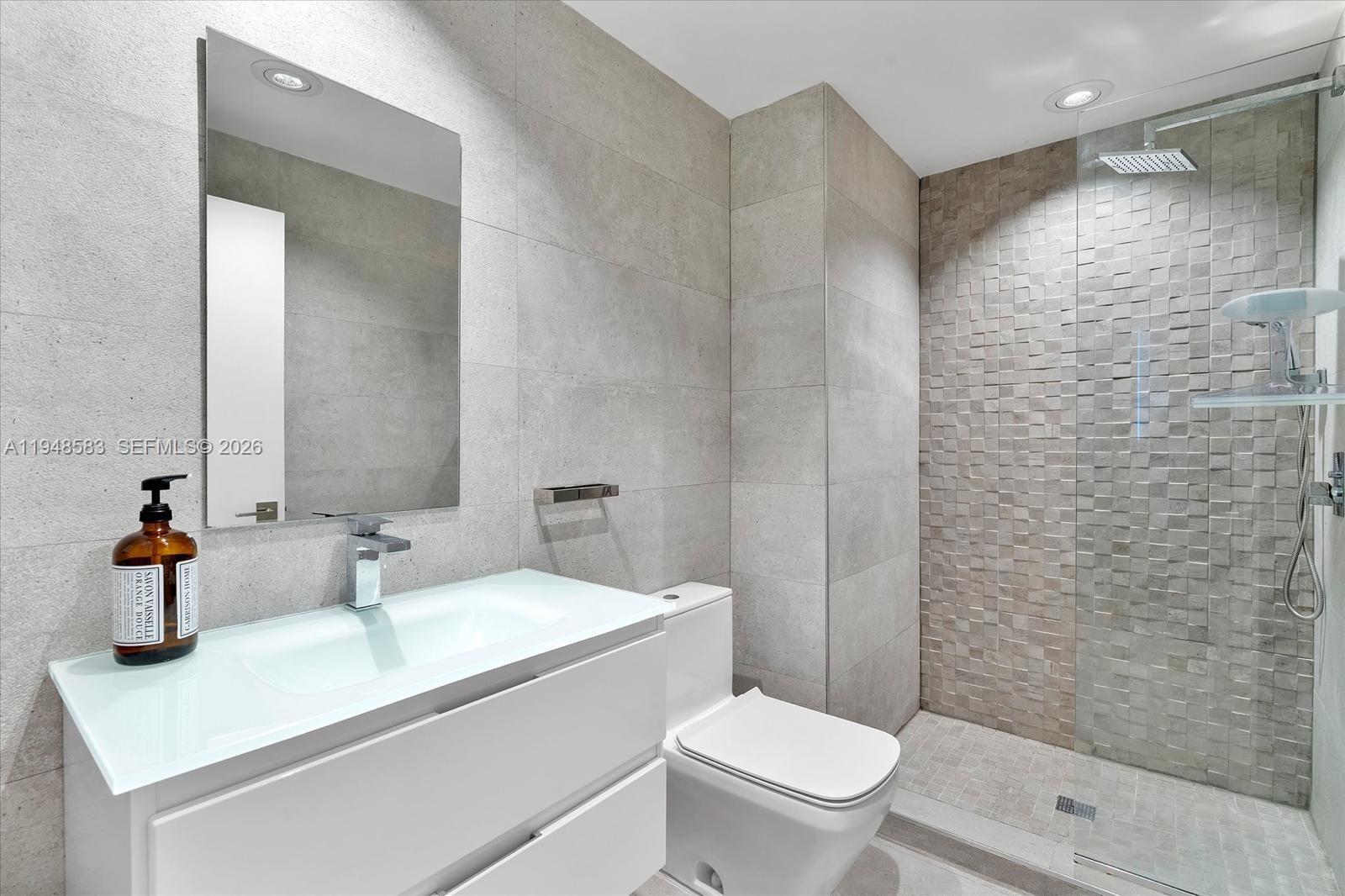 601 Northeast 36th Street, Unit 1310 Miami, FL 33137 - Photo 24 of 40 a bathroom with a sink a toilet and shower