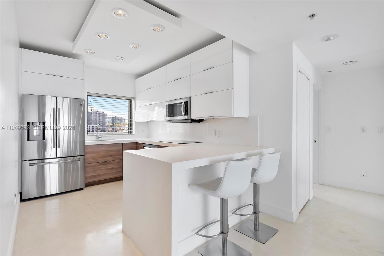 601 Northeast 36th Street, Unit 1310 Miami, FL 33137 - Photo 6 of 40 a kitchen with stainless steel appliances a refrigerator stove microwave and cabinets