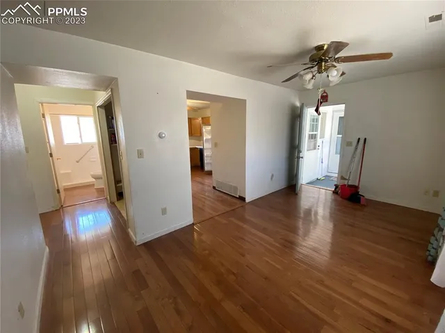 a view of a big room with wooden floor and a chandelier